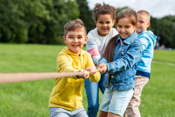 Gelukkige kinderen die touwtrekken in het park — Stockfoto
