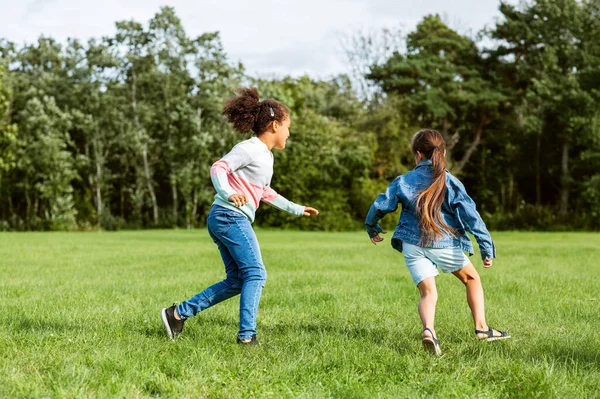 Gelukkig meisjes spelen en lopen in park — Stockfoto