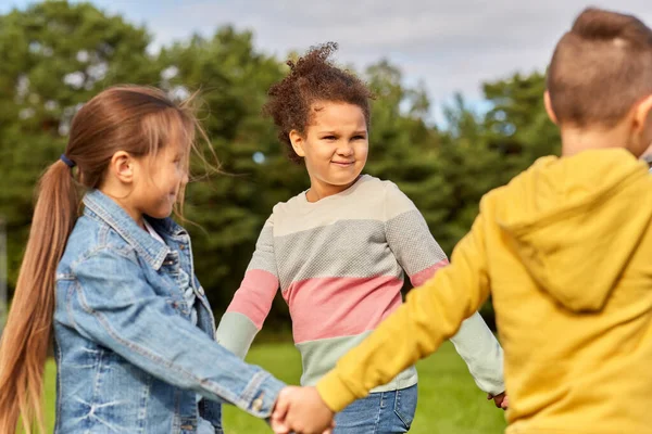 Niños felices jugando danza redonda en el parque —  Fotos de Stock