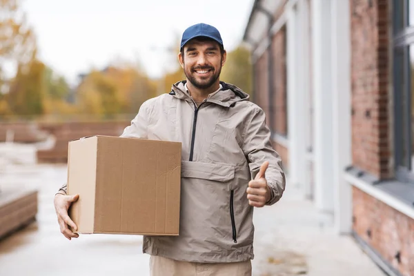 Homem de entrega com caixa de parcela mostrando polegares para cima — Fotografia de Stock