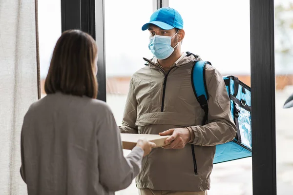 Consegna cibo uomo in maschera dando ordine al cliente — Foto Stock