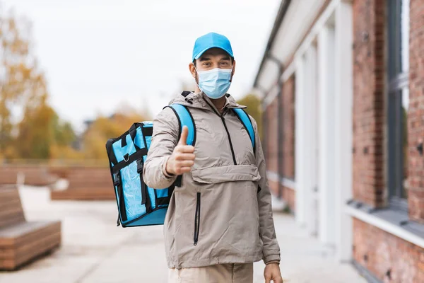 城市里戴口罩提热袋的送货人 — 图库照片
