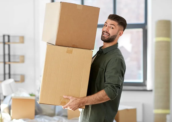 Happy man with boxes moving to new home — Stock Photo, Image