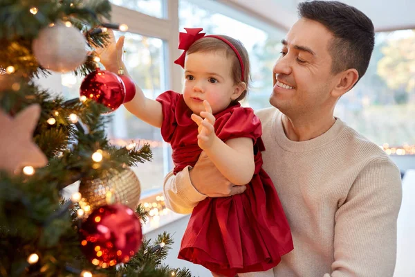 Šťastný otec a dítě dívka zdobí vánoční stromek — Stock fotografie