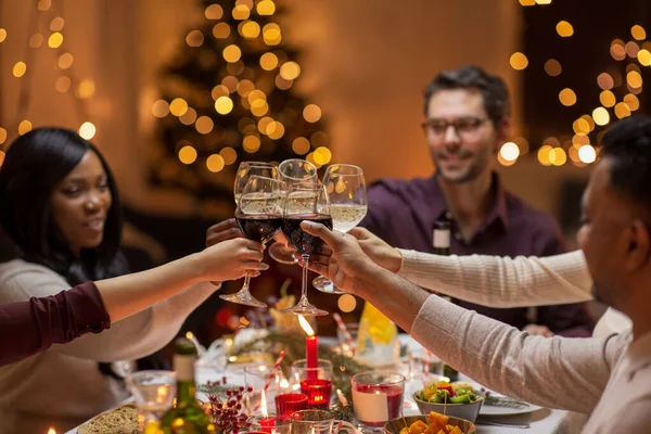 Glada vänner dricka vin på julfesten — Stockfoto