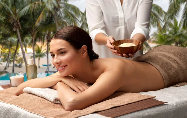 Mujer y cosmetóloga con sal en el spa — Foto de Stock