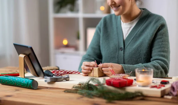 Tabletli mutlu kadın Noel hediyesi paketliyor. — Stok fotoğraf