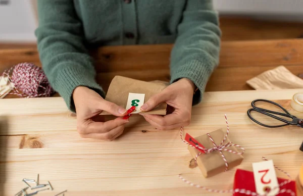 Mãos fazendo calendário do advento do Natal em casa — Fotografia de Stock