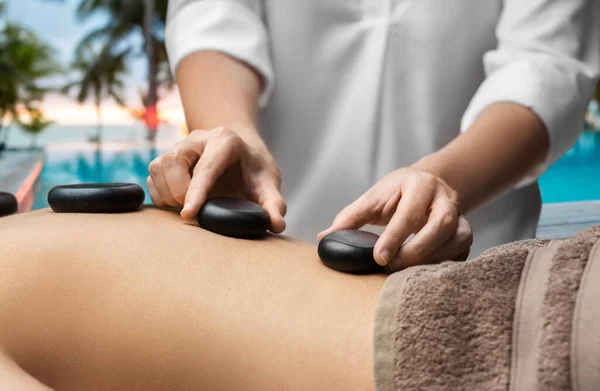 Närbild av kvinna som har varm sten massage på spa — Stockfoto