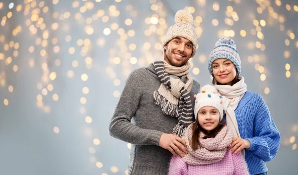 Família feliz em roupas de inverno em fundo cinza — Fotografia de Stock
