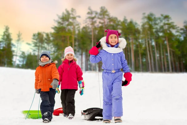 Χαρούμενα μικρά παιδιά με έλκηθρα το χειμώνα — Φωτογραφία Αρχείου