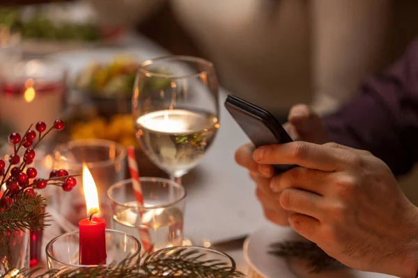 Mãos com smartphone no jantar de Natal — Fotografia de Stock
