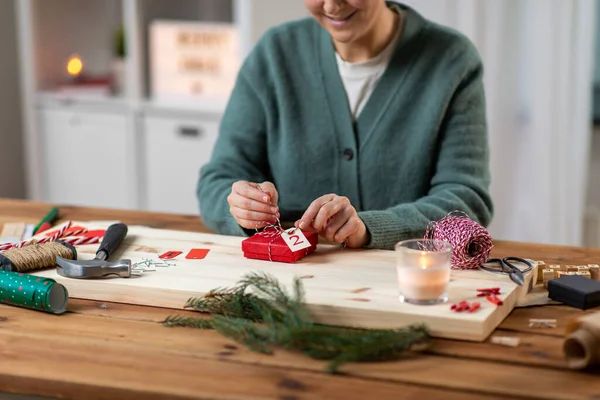 クリスマスに自宅でアドベントカレンダーを作る女性は ストックフォト