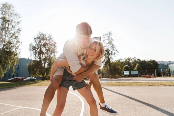Счастливая пара веселится на баскетбольной площадке — стоковое фото