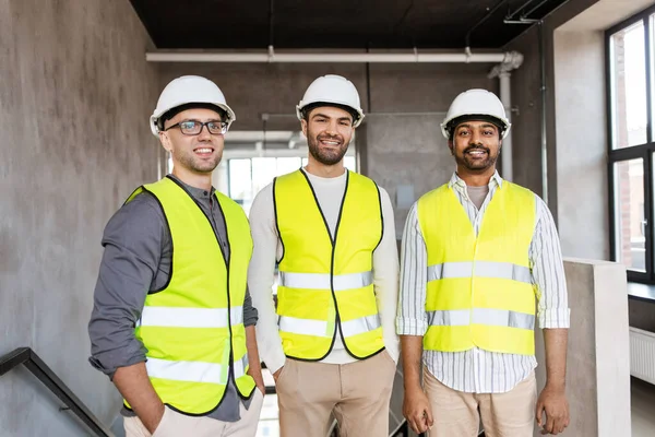 Glada leende manliga arkitekter i hjälmar på kontoret — Stockfoto