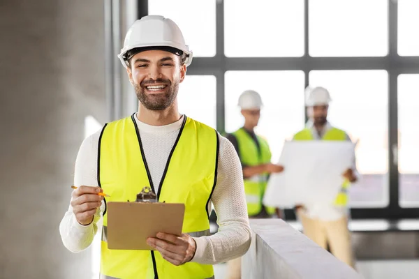 Architekt mit Helm und Klemmbrett im Büro — Stockfoto