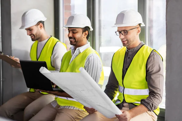 Arquitectos masculinos en cascos trabajando en la oficina —  Fotos de Stock