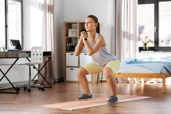 Evde yoga minderiyle egzersiz yapan mutlu genç kız. — Stok fotoğraf