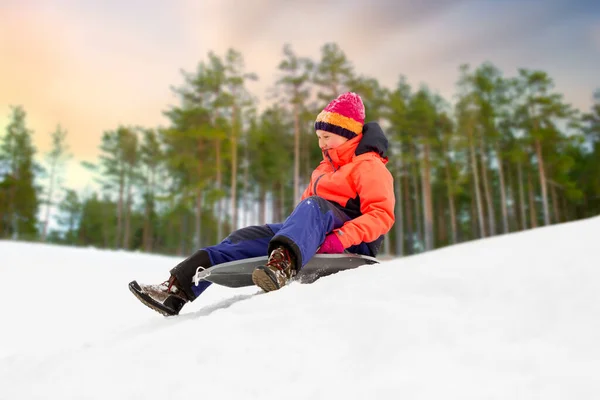 Felice ragazza scivolare giù sulla slitta in inverno — Foto Stock