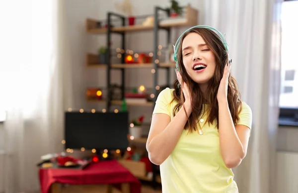 Šťastná mladá žena se sluchátky na Vánoce — Stock fotografie