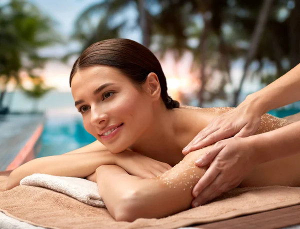 Mujer feliz teniendo masaje de sal exfoliante en el spa —  Fotos de Stock