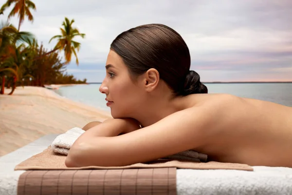 Young woman lying at spa over exotic beach — Stock Photo, Image