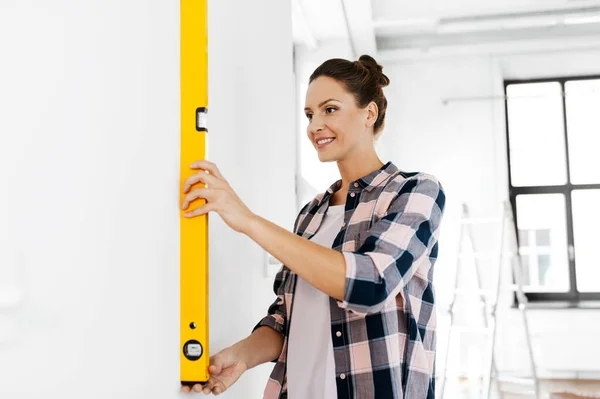 Mujer feliz con pared de medición de nivel en casa —  Fotos de Stock