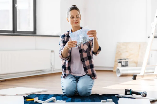 Woman with accessory assembling furniture at home — Stock Photo, Image