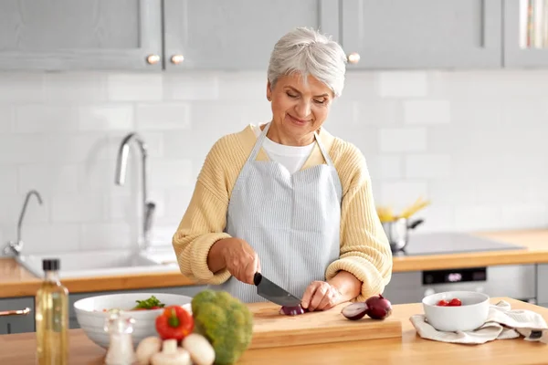 Boldog nő vágás piros hagyma a konyhában — Stock Fotó