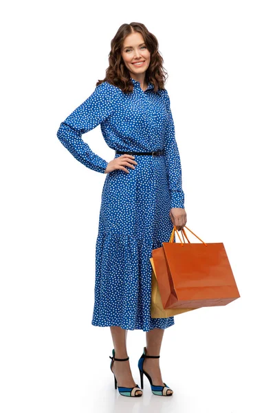 Felice giovane donna in abito blu con borse della spesa — Foto Stock