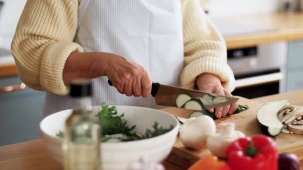 Hände einer Frau hacken Zucchini in der Küche — Stockvideo