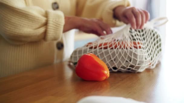 Woman with vegetables in string bag on kitchen — Stock Video