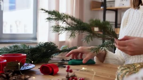 Szczęśliwa kobieta robi jodłę świąteczny wieniec w domu — Wideo stockowe