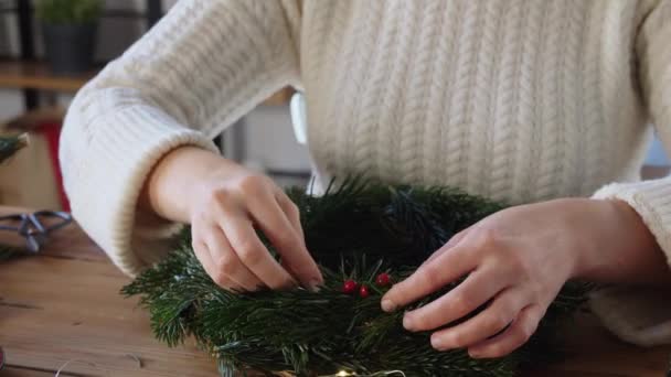 Femme faisant une couronne de Noël de sapin à la maison — Video