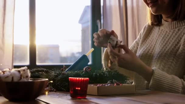 Щаслива жінка робить яскравий різдвяний вінок вдома — стокове відео