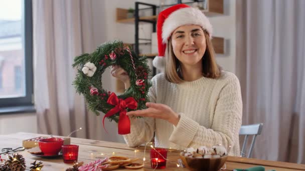 Gelukkig vrouw tonen sparren kerst krans thuis — Stockvideo