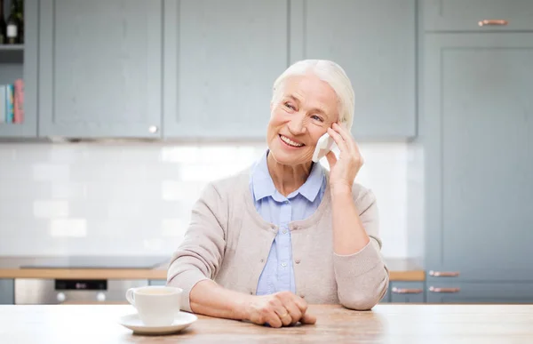 Boldog nő okostelefon hívja a konyhában — Stock Fotó