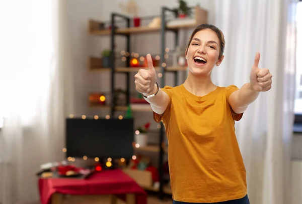 Joven mujer mostrando pulgares hacia arriba en la Navidad —  Fotos de Stock