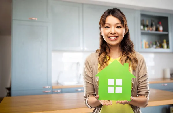 Mujer feliz con casa verde en la cocina —  Fotos de Stock