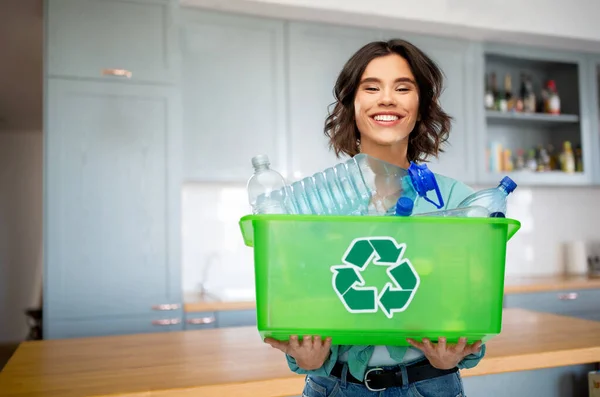 Boldog fiatal nő válogatás műanyag hulladék a konyhában — Stock Fotó
