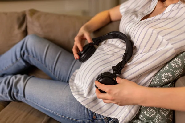 Schwangere mit Kopfhörern auf dem Bauch — Stockfoto