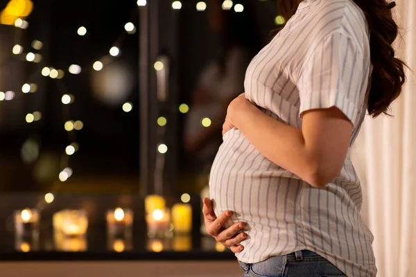 Zbliżenie kobiety w ciąży w oknie w domu — Zdjęcie stockowe