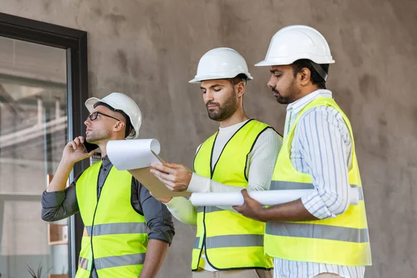 Arquitectos masculinos en cascos trabajando en la oficina —  Fotos de Stock