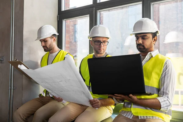 Männliche Architekten in Helmen mit Laptop im Büro — Stockfoto