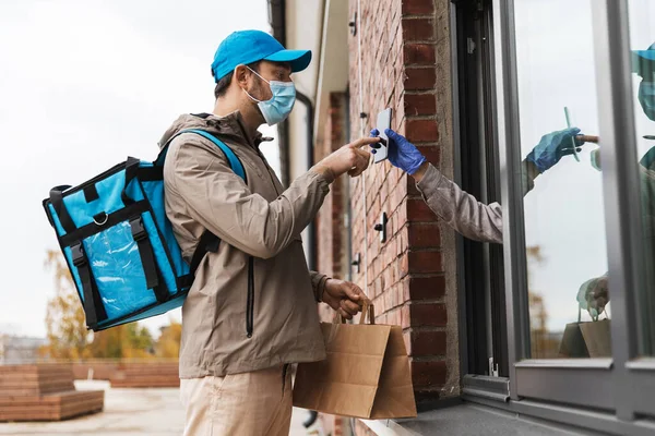 Hombre de entrega de alimentos en la máscara dando orden al cliente — Foto de Stock