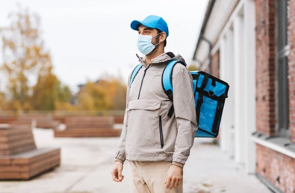 城市里戴口罩提热袋的送货人 — 图库照片