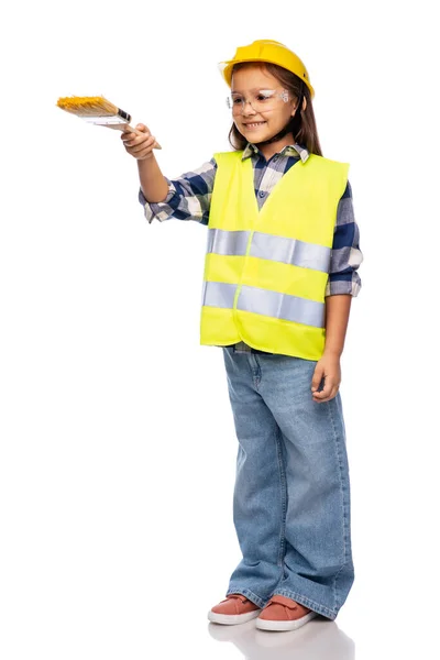 Meisje in helm en veiligheidsvest met penseel — Stockfoto