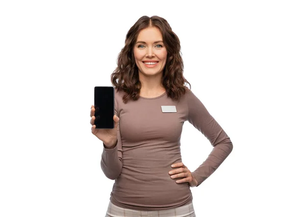 Happy female shop assistant showing smartphone — Stock Photo, Image