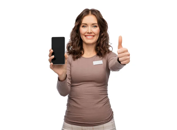 Happy female shop assistant showing smartphone — Stock Photo, Image