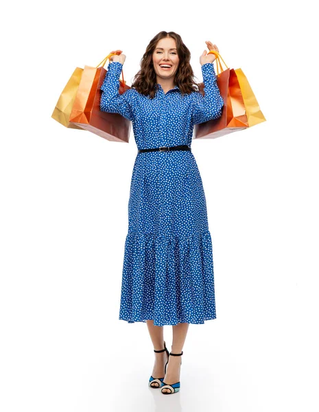 Felice giovane donna in abito blu con borse della spesa — Foto Stock
